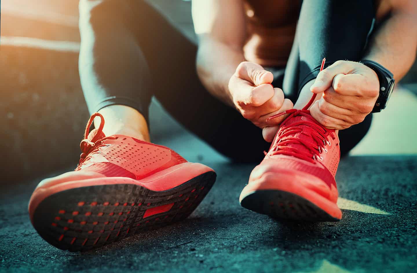 Close up of runner tying shoes