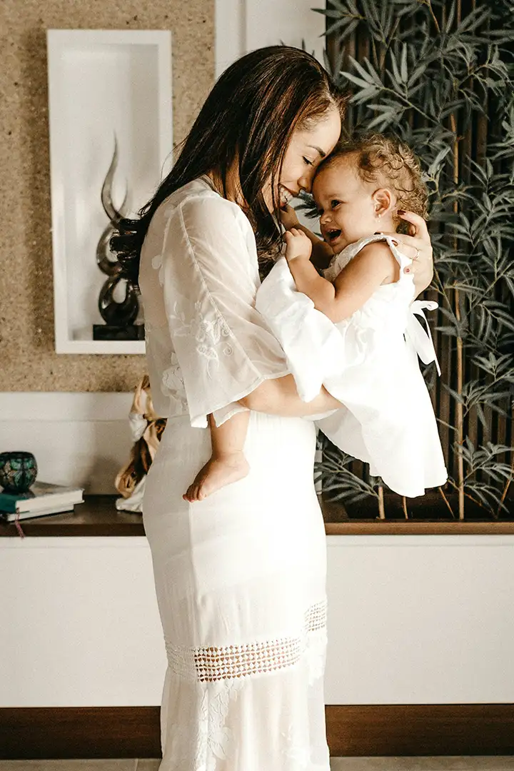 Pregnant mom and young daughter hugging and laughing