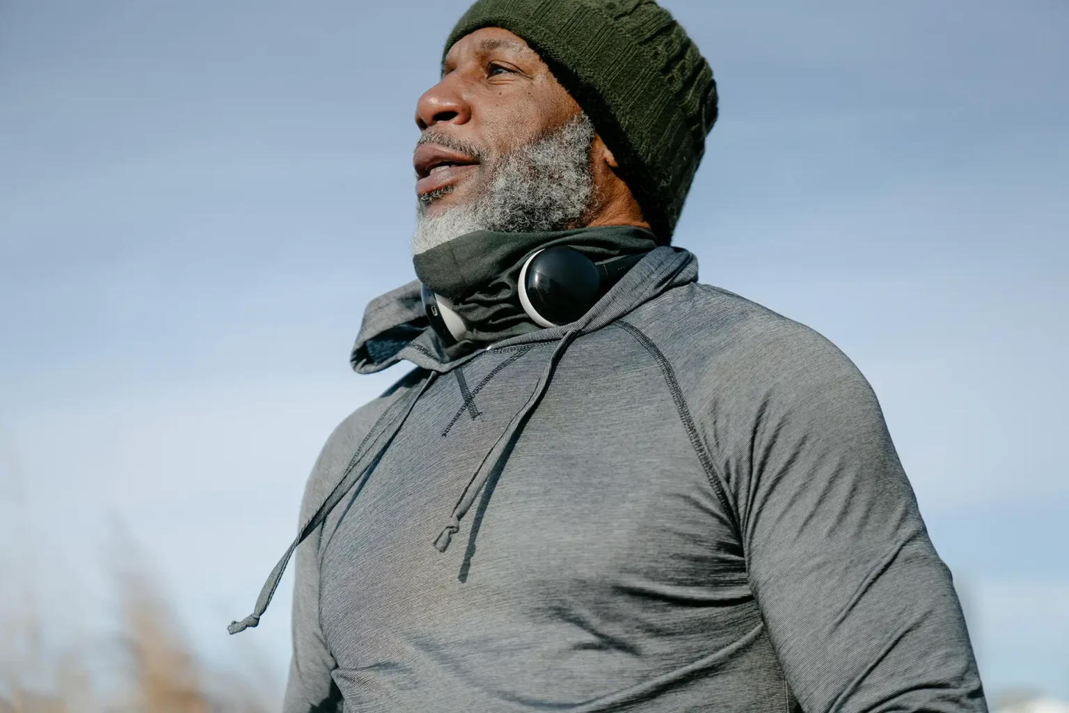 Senior man with headphones and beanie enjoying outdoor exercise