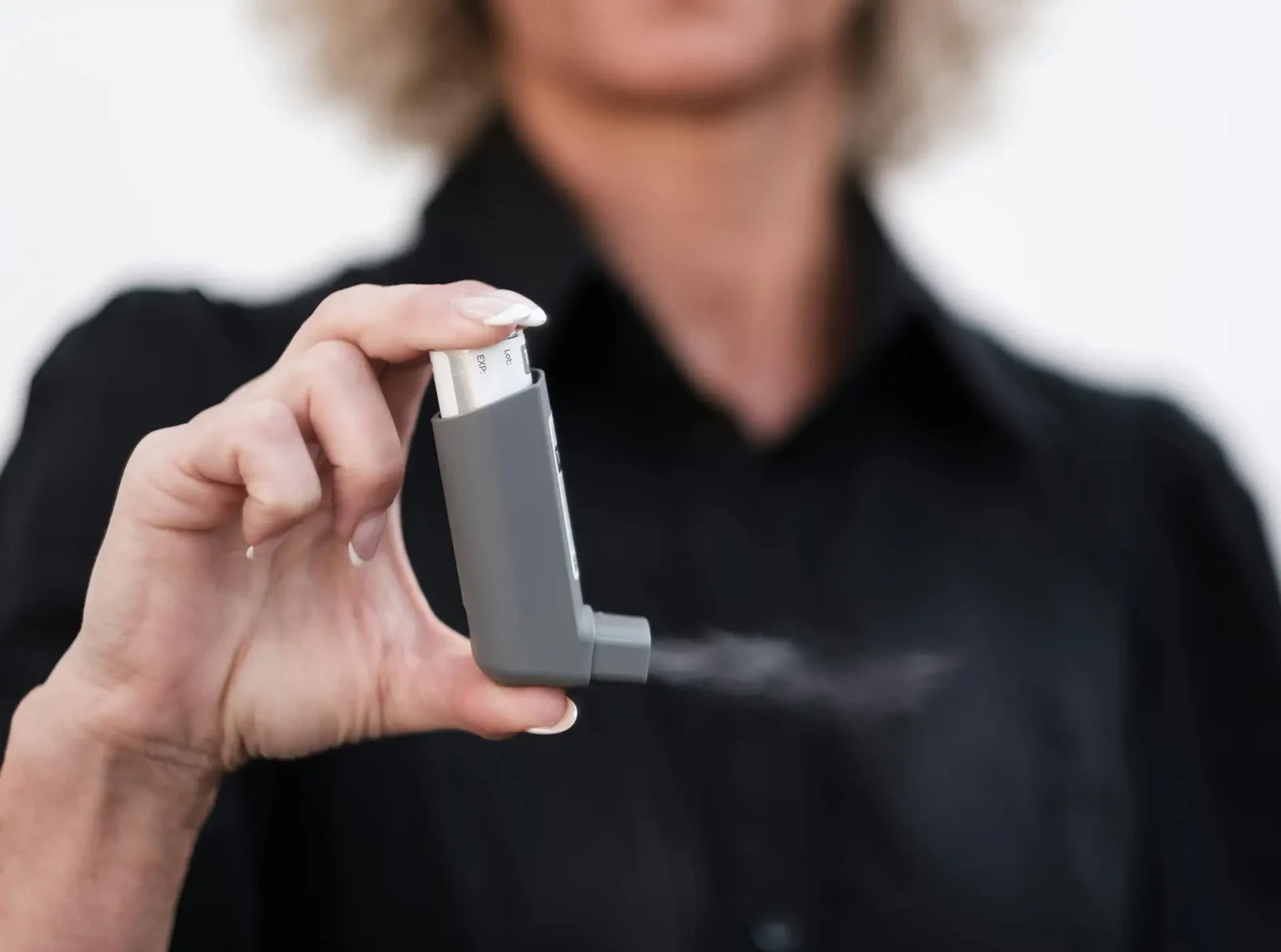 Woman holding asthma inhaler