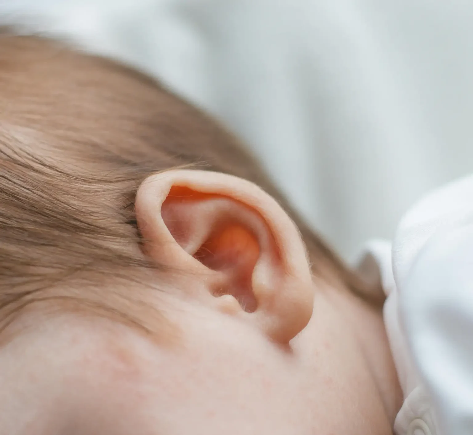Detailed close-up of a newborn baby's ear, capturing softness and innocence