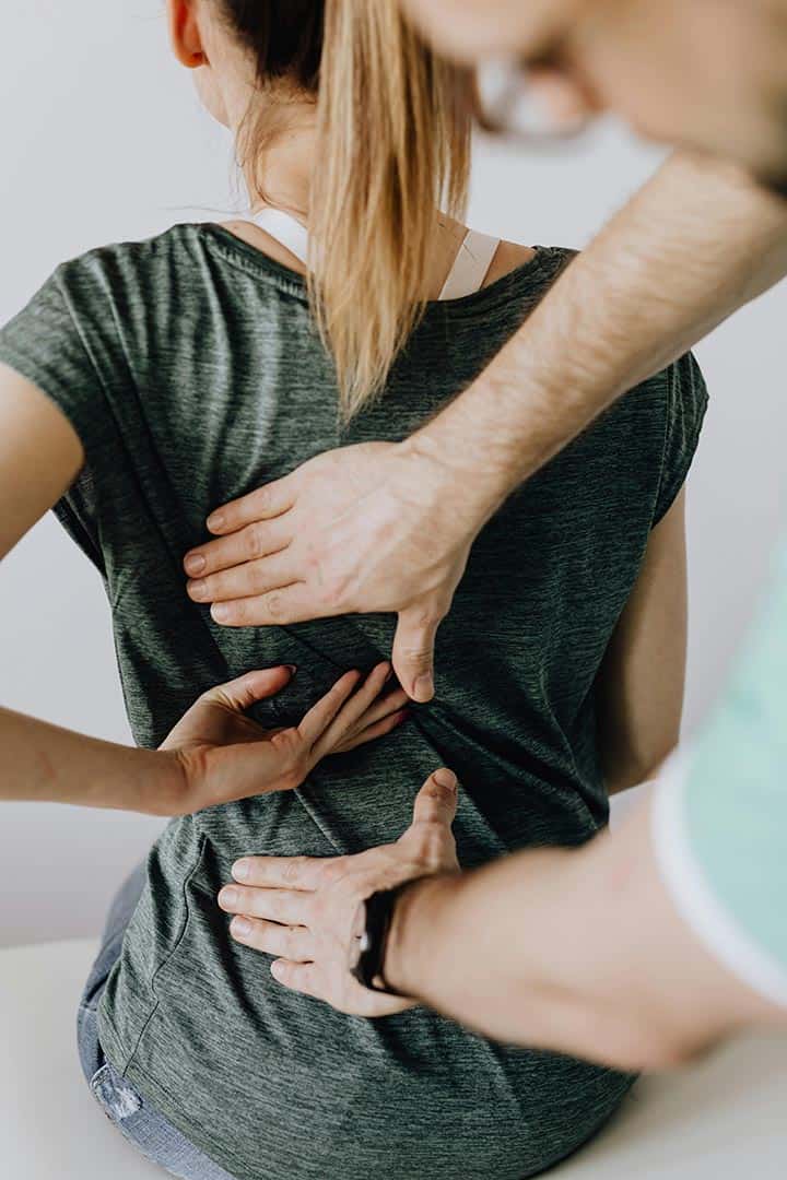 Woman getting examination and chiropractic adjustment