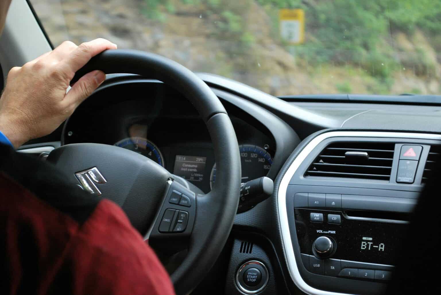 Person driving with hand on Steering Wheel