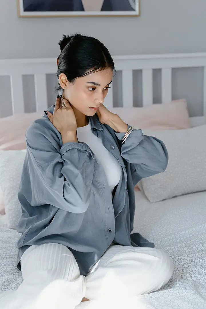 Woman massaging sore neck, attempting to reduce migraine and headache pain
